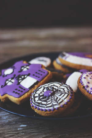 Royal icing cookies-plate with decorated purple cookies in different shapes and decoration; on...