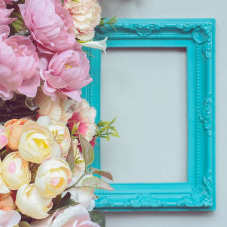 Composition made of decorative picture frame and pastel colored flowers; with copy spaceの写真素材