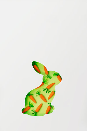 Easter bunny greeting card, with copy space; Cut out bunny shape with small decorative carrots in the backgroundの写真素材