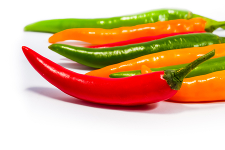 Red and green and yellow  chilli peppers on white backgroundの写真素材