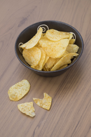 Potato chips on  plate on wood tableの写真素材
