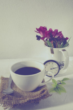 Stopwatch and  flowers in a cup, Still life. Romantic background with retro filter effectの写真素材