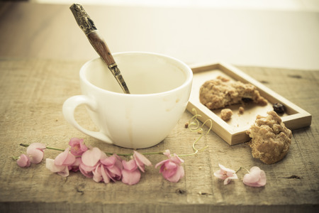 Empty coffee cup wood ,beautyful light,empty coffee have spoon and cookies. Vintage effect filter style picturesの写真素材