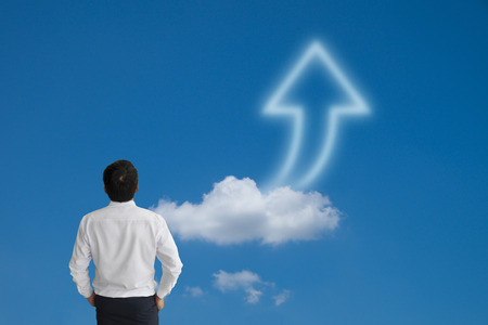 Business man purposefully looking away with arrow cloud and blue sky, model is a asian maleの写真素材