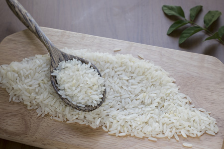 Uncooked rice in a wooden spoon . Selective focusの写真素材