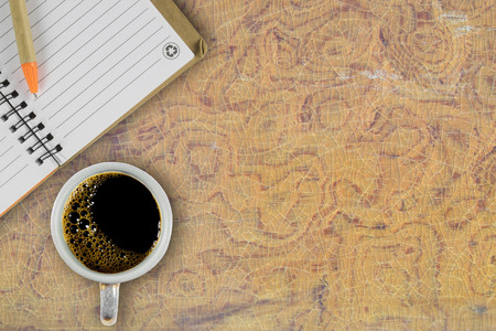 Note book with coffee cup on wood table. Top view.の写真素材
