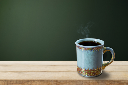 Empty coffee cup on wood table over grunge backgroundの写真素材