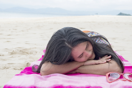Woman relaxing on the beach. Young attractive woman near the ocean on a summer dayの写真素材