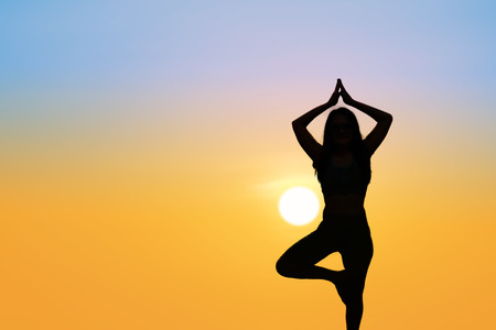 Silhouette Asia woman yoga on the beach at sunset. Sunset sky backgroundの写真素材