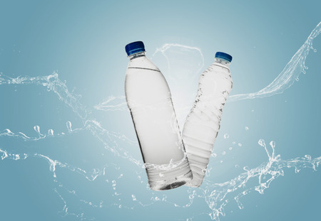 Bottle of water splash on a blue backgroundの写真素材