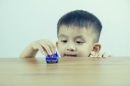 Little boy playing with toy car at home. Selective focus, Filtered image processed vintage effect.の写真素材