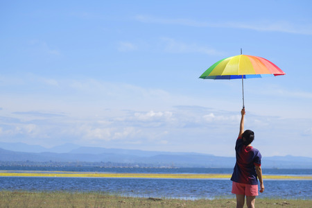 Beautiful woman holding multicolored umbrella.