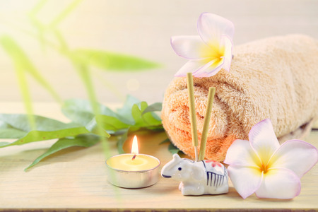 SPA concept:Spa towels and flowers and candles on wooden table.の写真素材