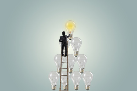 Inspiration concept businessman standing on a ladder with light bulb, Business Conceptの写真素材