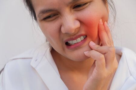 Beautiful Young Woman Suffering From Terrible Strong Teeth Pain, Touching Cheek With Hand.Tooth Pain And Dentistry.  Dental Care And Health Concept.の写真素材