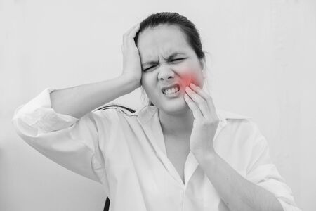 Beautiful Young Woman Suffering From Terrible Strong Teeth Pain, Touching Cheek With Hand.Tooth Pain And Dentistry.  Dental Care And Health Concept.の写真素材