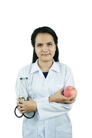 Doctor holding a fresh apple on white backgroundの写真素材