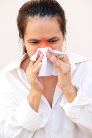 Asian woman use of the tissue. Sick young woman girl sneezing in tissue isolated on white background. Health care concept.の写真素材