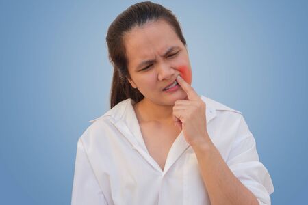 Beautiful Young Woman Suffering From Terrible Strong Teeth Pain, Touching Cheek With Hand. Tooth Pain And Dentistry.  Dental Care And Health Concept.の写真素材