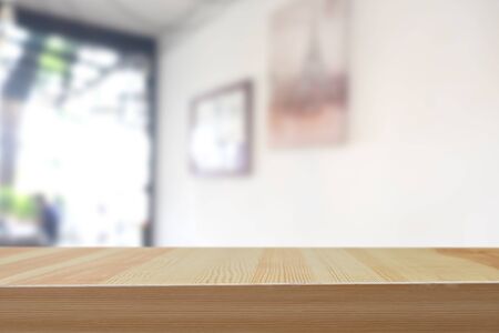 wooden table in front of abstract blurred bokeh background of coffee shop.の写真素材