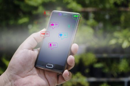 Close up of a man using mobile smartphone,social media or network on smartphone mobile, comments, likes and new followers, communication onlineの写真素材