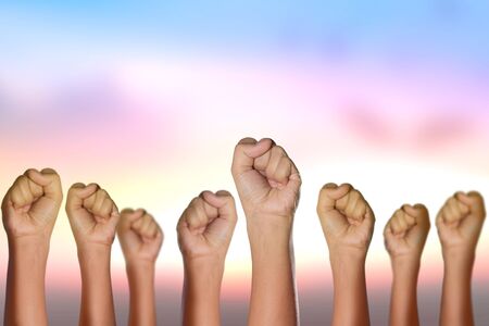 Teamwork concept,Peoples raised fist air fighting and sunlight effect, Competition, background space for text.の写真素材
