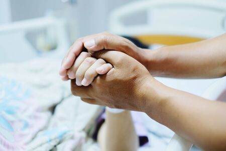Close up focus on the Shake hands of a patient sick encourage encouragement on the bed in hospital ward. Healthcare concept.の写真素材