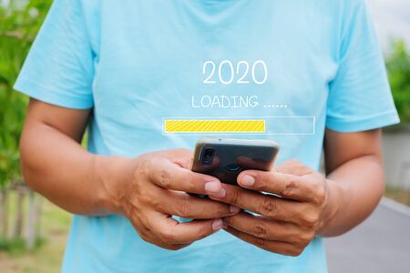 Loading 2020 with young man using a smartphoneの写真素材