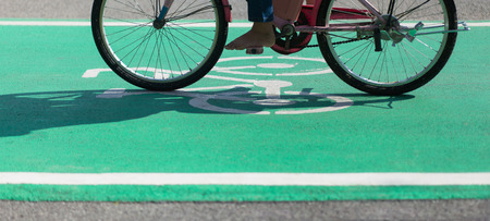 Barefoot Cycling on Bike Path Green Lane with the Bikeway Symbol in Bangkok Public Parkの写真素材