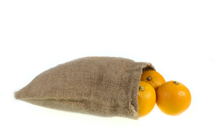 oranges in burlap sack, isolated on white backgroundの写真素材