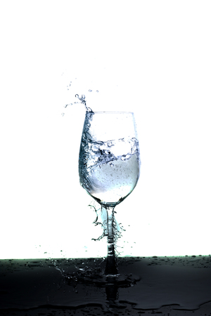 glass with water splash over white backgroundの写真素材