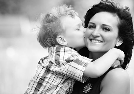 Mother Mum and her child son kissing and she is very happy. good relationship in this familiy is...