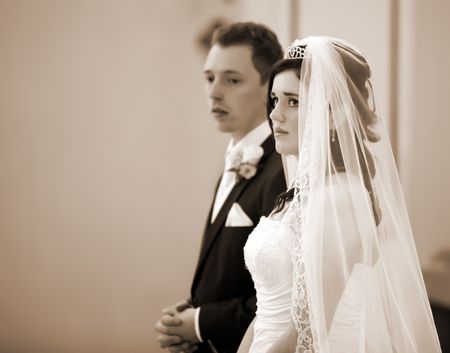 Photo shows young bride and fiancé in the church. it is a sepia black and white wedding photo.の写真素材