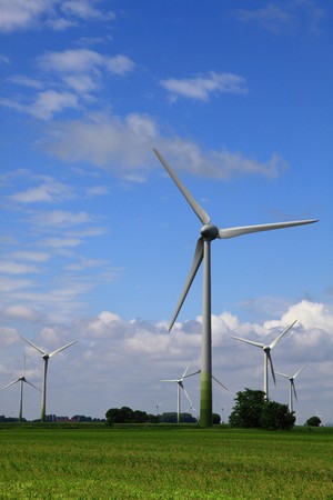 Wind Ernergie energy - turbine generator below nice blue cloudy sky. another group of windmills as alternative energy are in the backgroundの写真素材