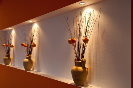 Three vases on a wall podest with warm light from aboveの写真素材