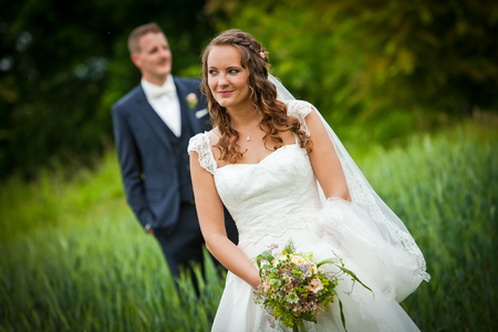 wedding couple - nice pretty bride is looking with handsome husband in backgroundの写真素材