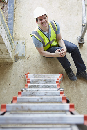 Construction Worker Falling Off Ladder And Injuring Legの写真素材