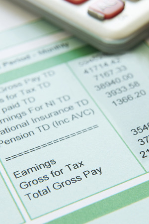 Close Up Of Pay Slip With Calculatorの写真素材