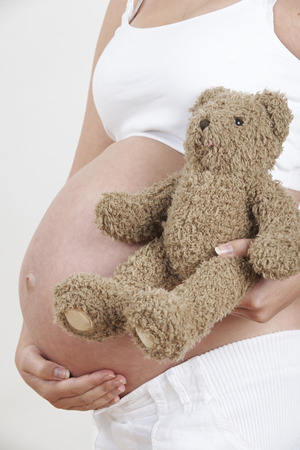 Close Up Of Pregnant Woman Holding Teddy Bearの写真素材