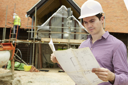 Architect On Building Site Looking At House Plansの写真素材