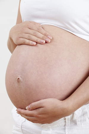 Close Up Of Pregnant Woman Holding Tummyの写真素材