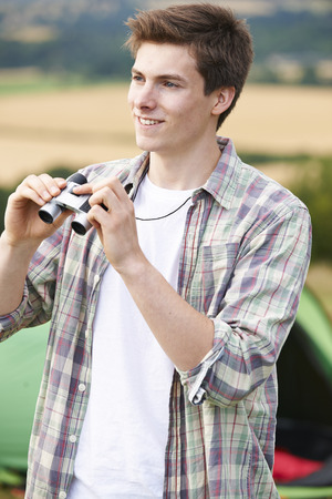 Young Man With Binoculars On Camping Tripの写真素材