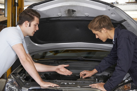 Mechanic Helping Apprentice To Fix Engineの写真素材