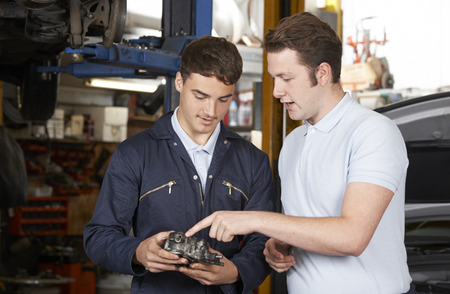 Mechanic Helping Apprentice To Fix Engineの写真素材