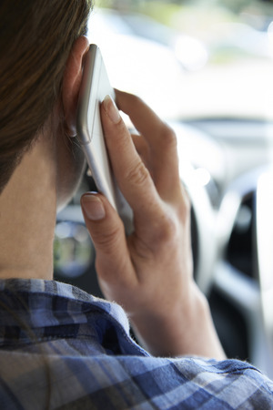 Woman In Car Talking On Mobile Phone Whilst Drivingの写真素材