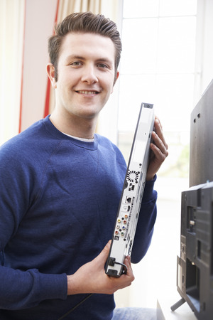 Portrait Of Engineer Installing Digital TV Equipmentの写真素材