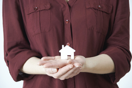 Woman Holding Model House In Palm Of Handの写真素材