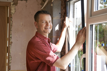 Construction Worker Installing New Windows In Houseの写真素材