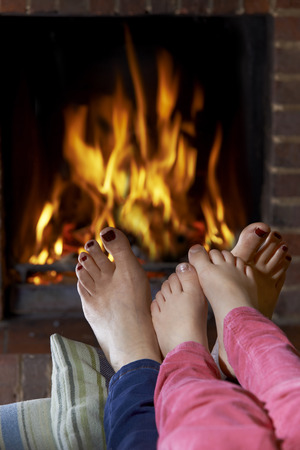 Mother And Child Warming Bare Feet By Fireの写真素材