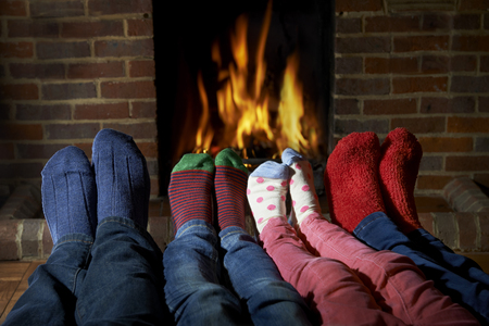 Family Wearing Socks Warming Feet By Fireの写真素材